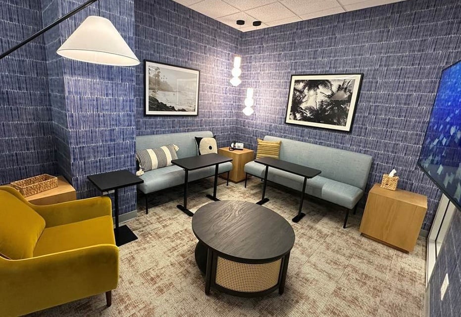 Sofa seating with TV display and tables in Honeycrisp meeting room in Cupertino