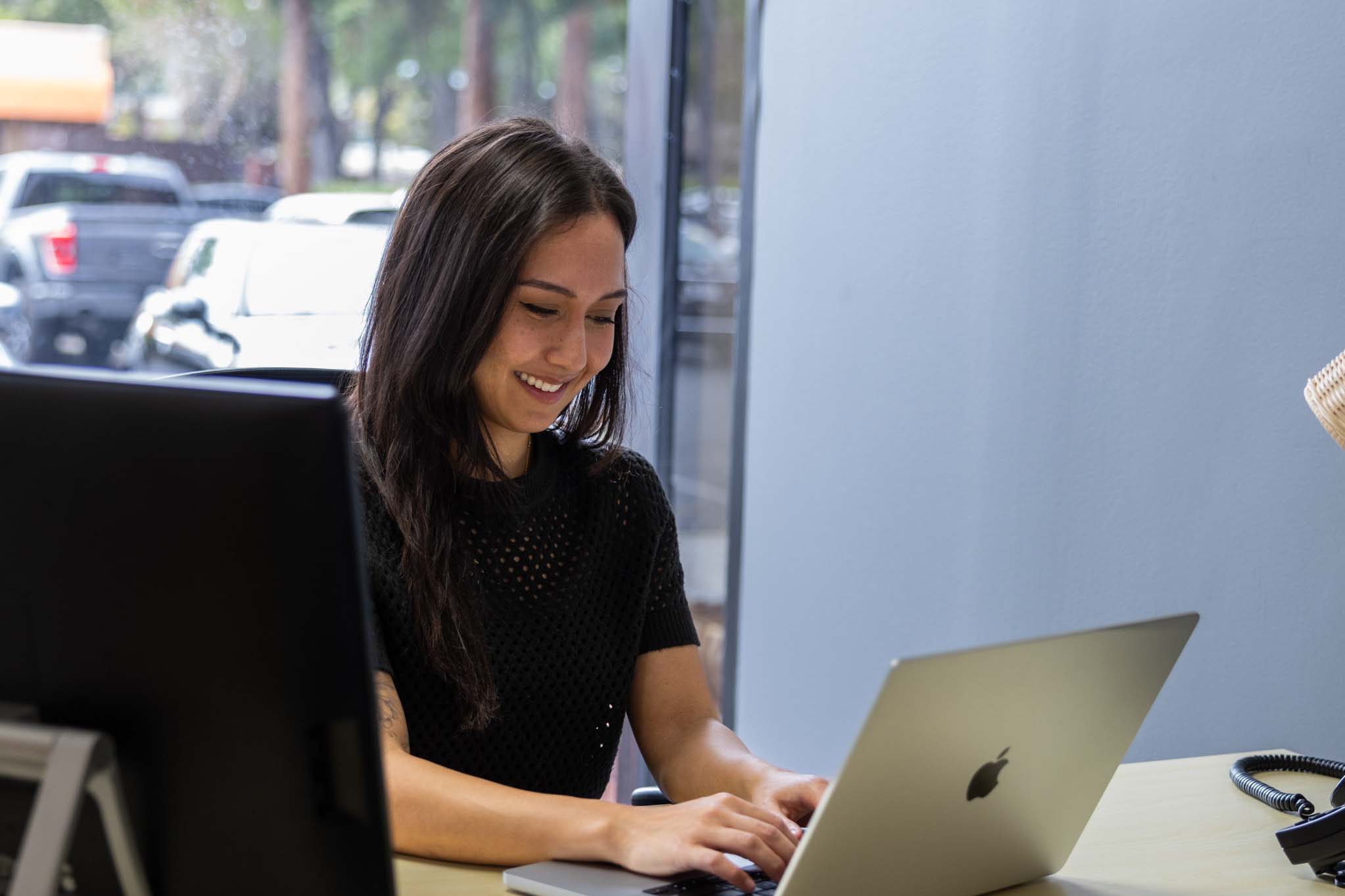 Woman using laptop at desk in private office space in Roseville