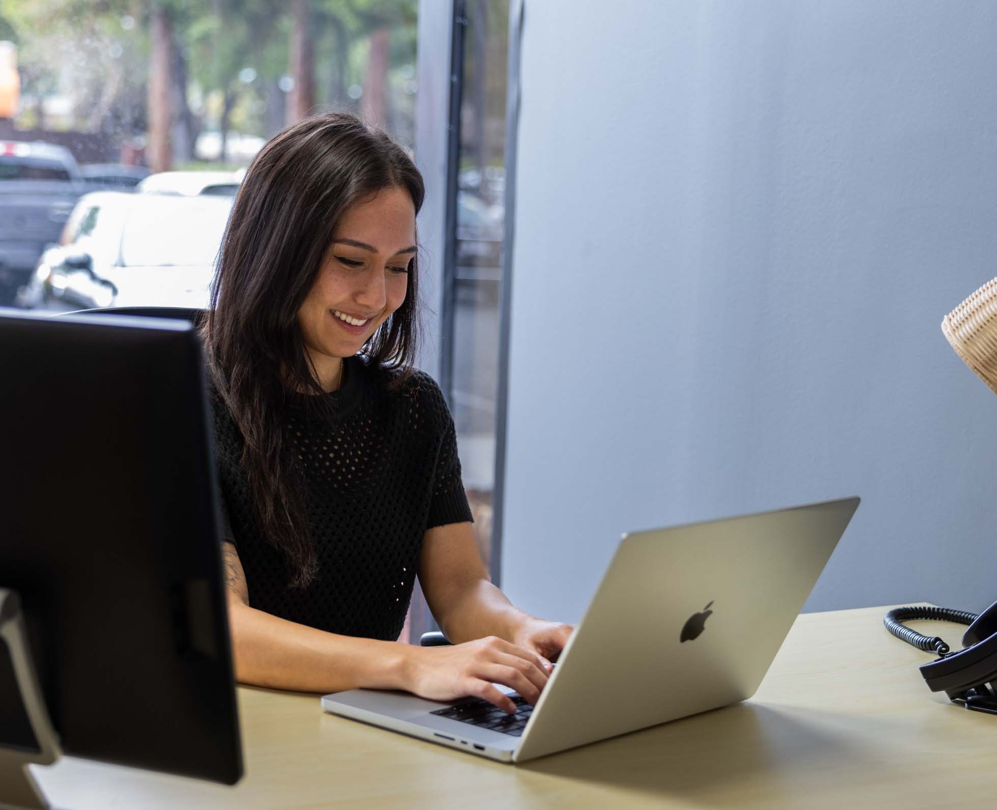 Woman working at desk with laptop in private office space in Berkeley