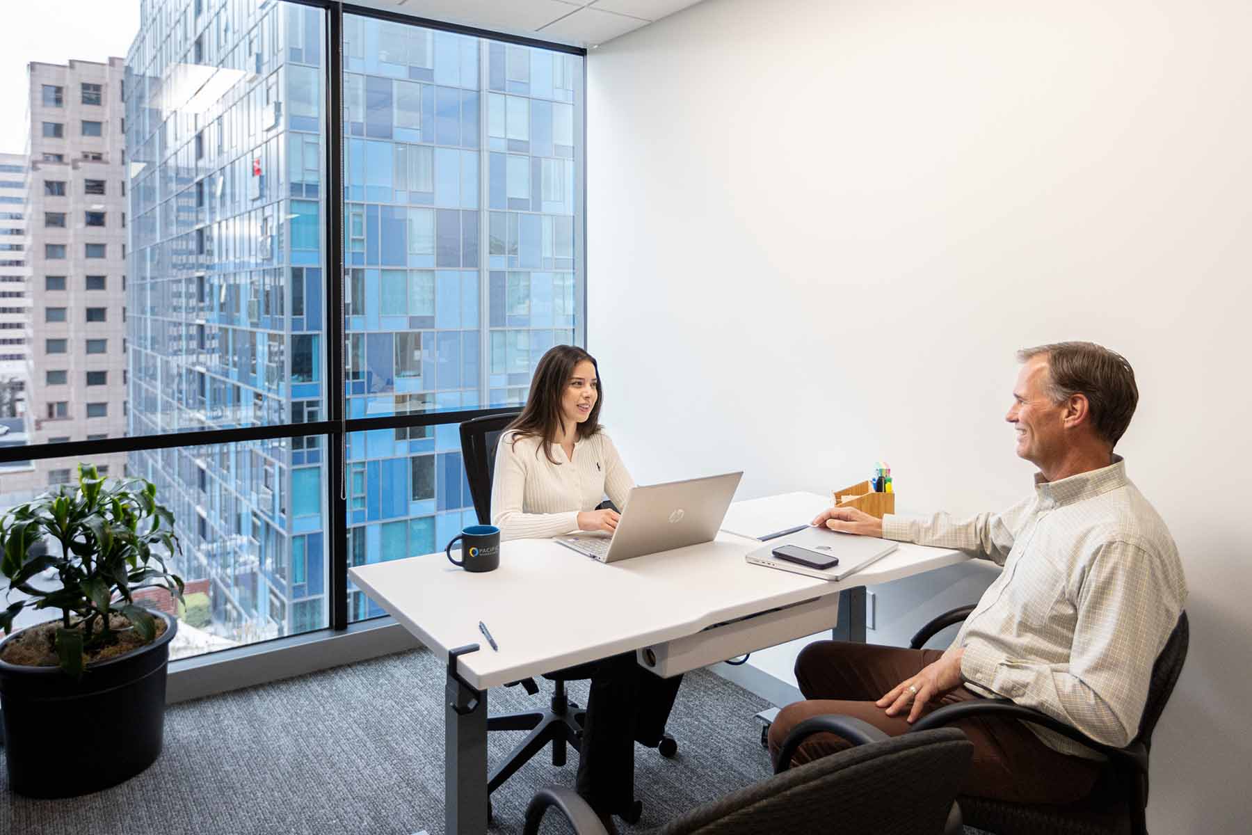 Two people sitting at a desk in a private office space in San Jose