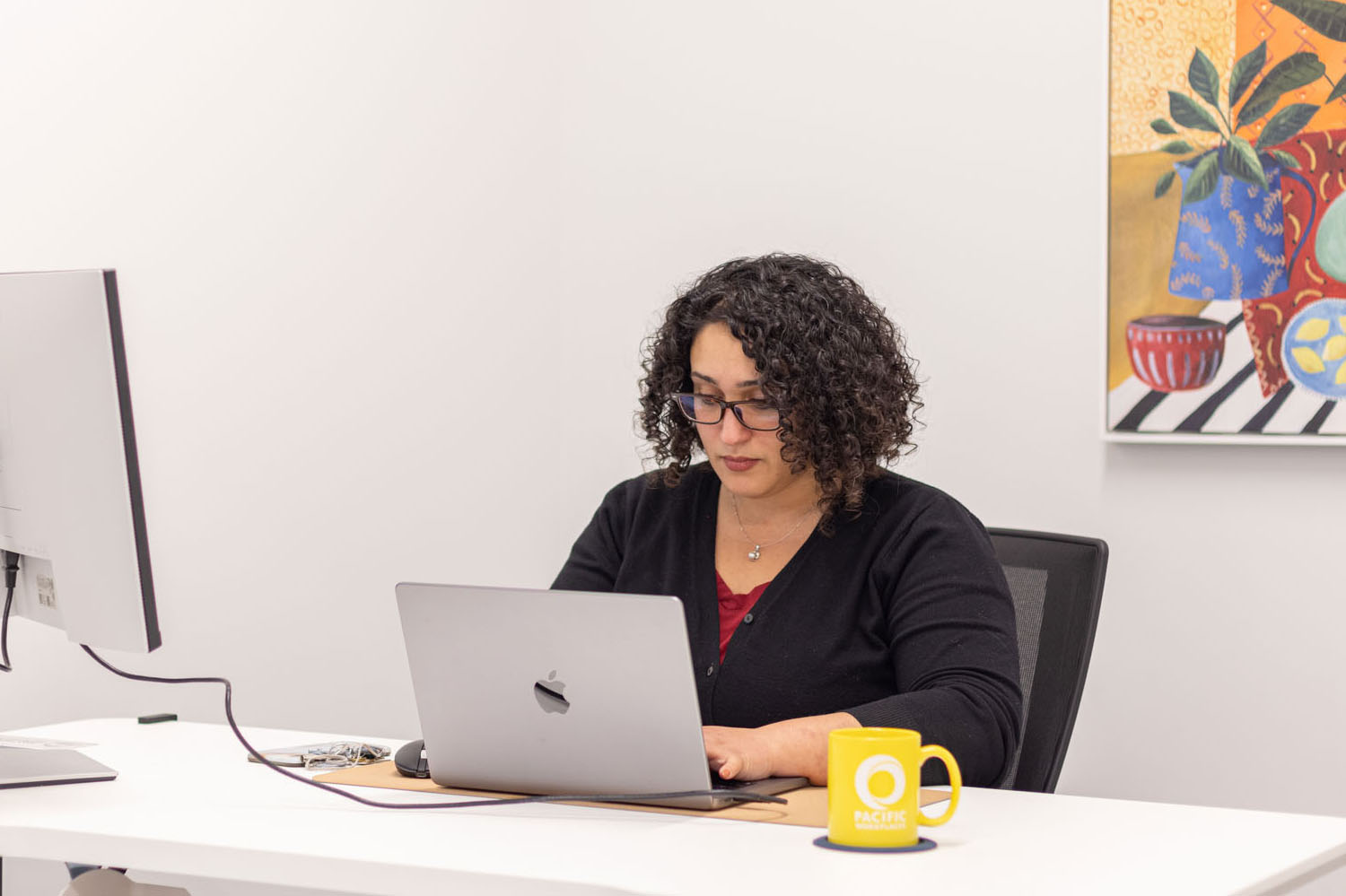 Woman working at desk with laptop in private office space in San Mateo