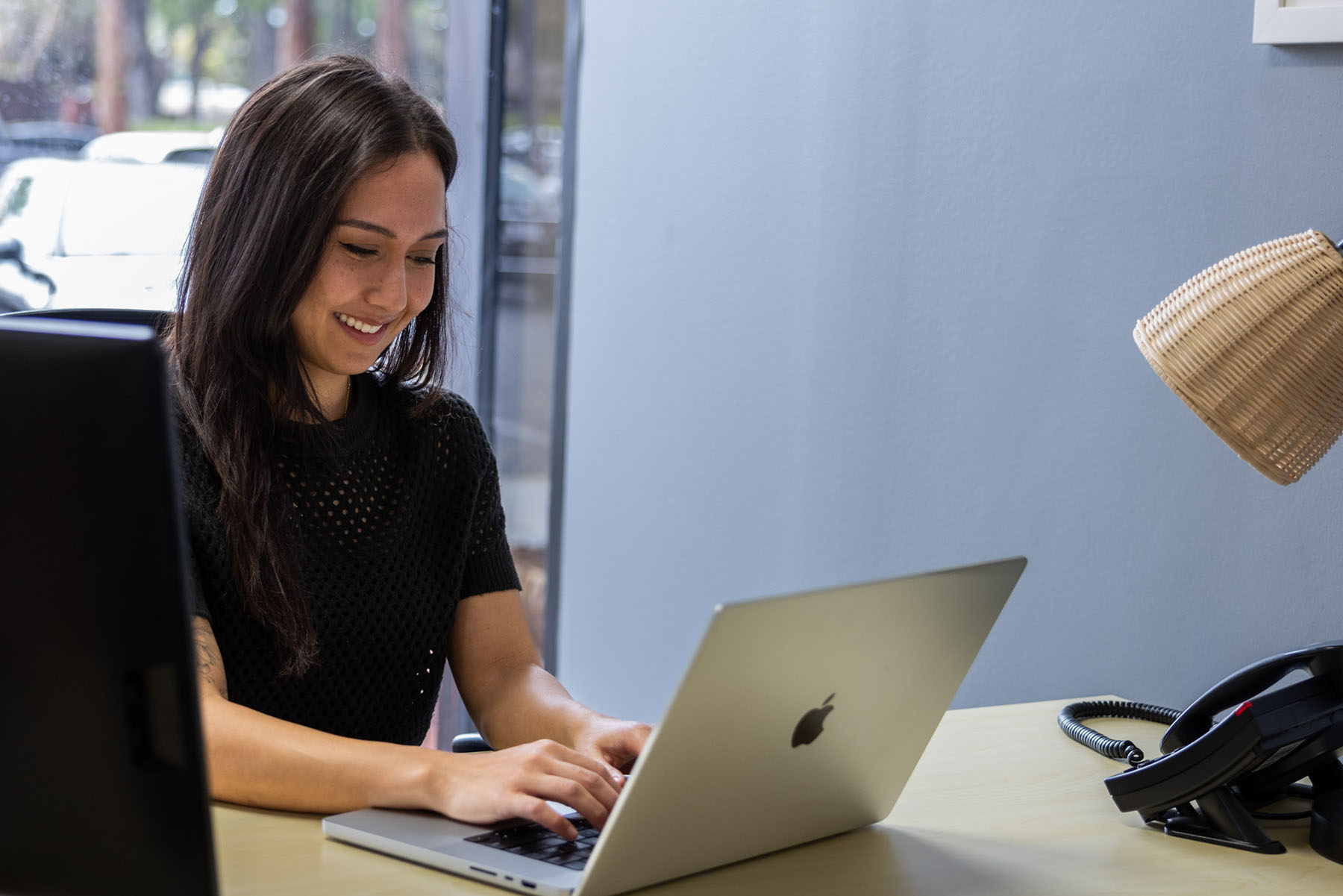 Woman working on laptop at desk in coworking space in Marin