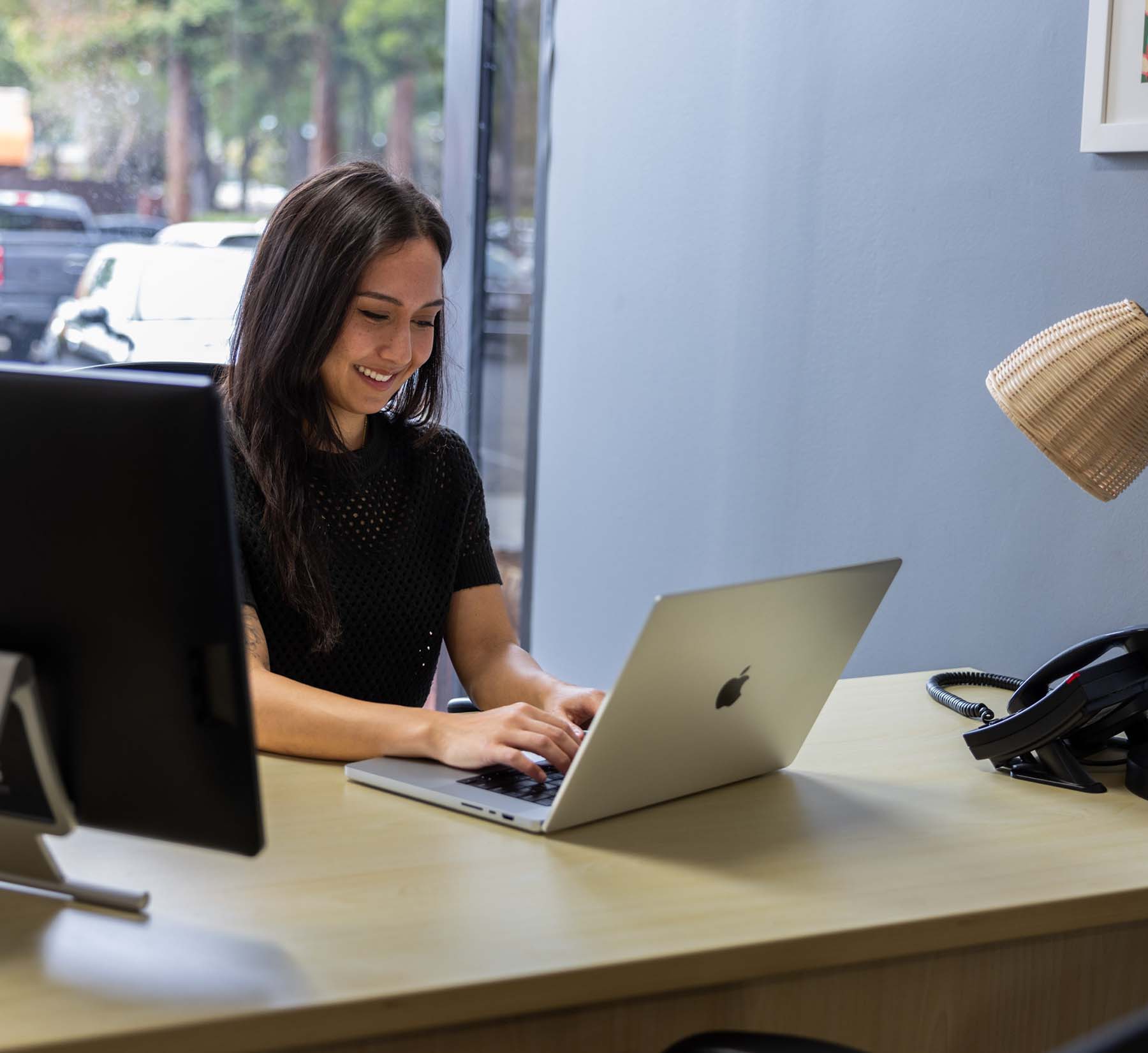 Woman working at desk with laptop in coworking space in Pleasant Hill