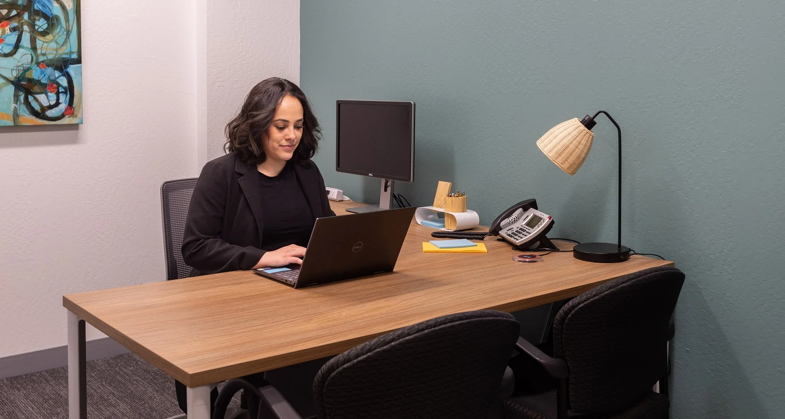 Woman works at desk with laptop in private office in San Mateo Woman works at desk with laptop in private office in San Mateo