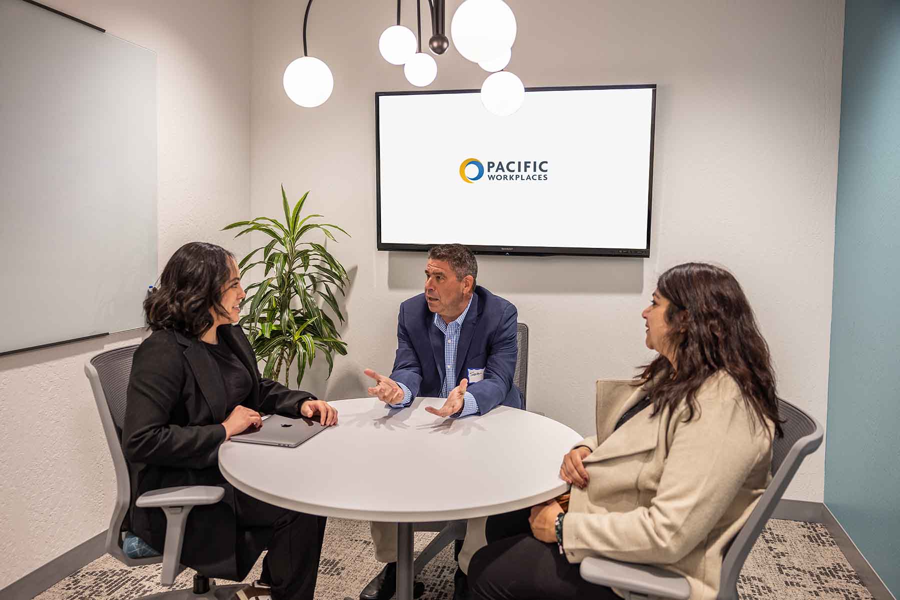 Pacific Workplaces_Sac_MeetingRooms man and two women using a Sacramento meeting room